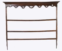 An unusual 18th Century oak plate rack, the concave cornice above a pierced undulating apron and