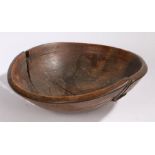 A 19th Century wooden bowl, with rivetted repairs to the bowl, 38cm diameter