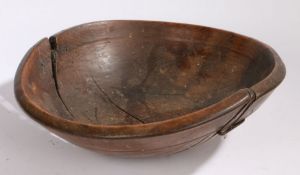 A 19th Century wooden bowl, with rivetted repairs to the bowl, 38cm diameter