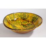 A large 19th Century French bowl, in mustard yellow glaze and brown and green leaf slip with a