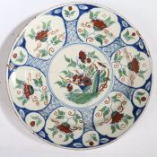An 18th Century English delft charger, Bristol circa 1730, with polychrome flower and rock centre
