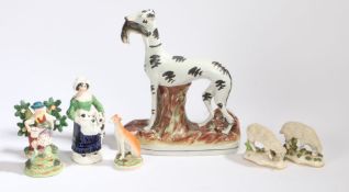 Staffordshire pottery, to include a Greyhound clutching a rabbit, a pair of sheep, a seated