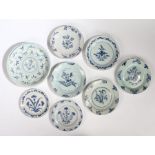A collection of eight 18th Century English Delft plates, each with a flower spray and leaf motif