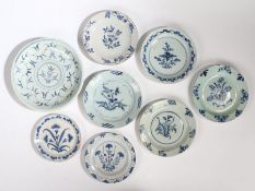 A collection of eight 18th Century English Delft plates, each with a flower spray and leaf motif