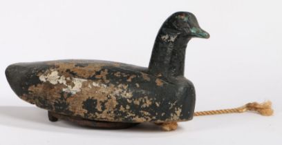 A decoy duck, painted in black with an applied horse shoe to the underside, 41cm long