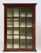 A 19th Century glazed hanging cabinet, the concave cornice above an astragal glazed door enclosing