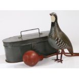 A whistling bird decoy, with a model partridge, rubber tubing and bellows to pump air into the