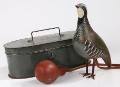 A whistling bird decoy, with a model partridge, rubber tubing and bellows to pump air into the