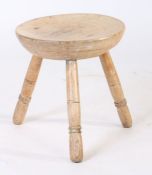 A 19th Century Welsh sycamore and oak stool, the circular dished top above three ring turned