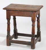A 17th Century style oak joint stool, with a rectangular top above turned legs united by stretchers,