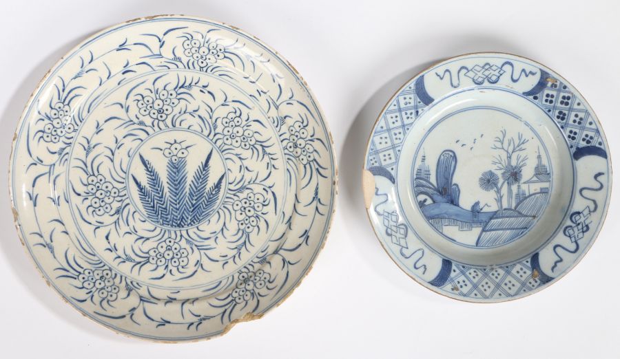 An 18th Century Delft dish, with a flower and leaf design, 22.5cm diameter, together with another