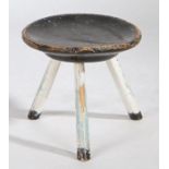 A 19th Century painted stool, the black painted circular dished top above three white painted turned