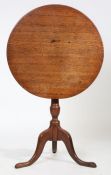 A George III oak occasional table, the circular tilt top above a turned column and sweeping cabriole