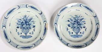 Pair of 18th Century Delft plates, circa 1760, each with a vase and bouquet of flowers with