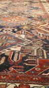 A Kurdish rug, Persia, with repeating motif in diamond lozenges together with floral guls with a