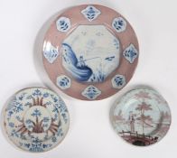 Three 18th Century English Delft plates, to include a manganese and blue painted charger with a