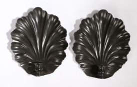 A pair of metal rococo scallop wall sconces, in the 18th Century manner, with a candle socket to the