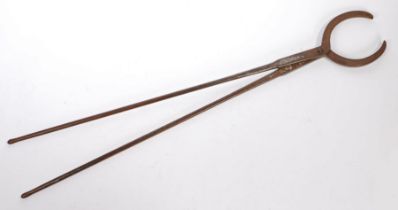 A 19th Century steel log tong, with hinged handles and a U shaped claw, 107cm long