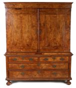 A good and large Northern European walnut cabinet on chest, the concave cornice above two cross