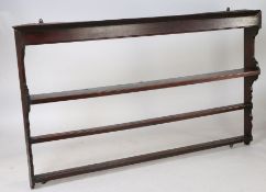 A George III oak plate rack, the concave cornice above three shelves and shaped side supports, 200cm
