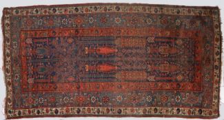 A Persian rug, set with trees and chevrons to the centre together with multiple repeating borders,