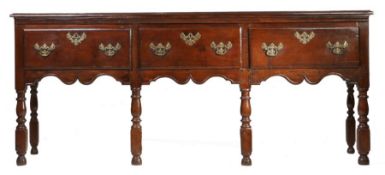 An 18th Century oak dresser, the rectangular top above three short drawers and an undulating apron