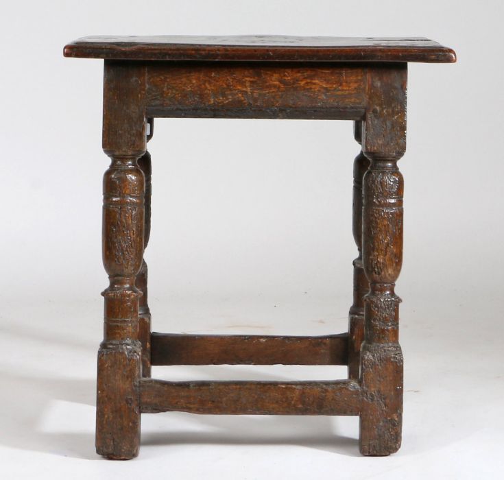 A Charles I oak joint stool, circa 1640, the rectangular top above turned legs united by stretchers,