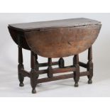 A Charles II oak gateleg table, circa 1680, the oval drop flap top above turned legs united by