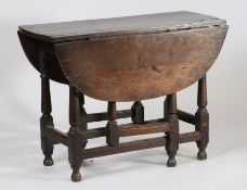 A Charles II oak gateleg table, circa 1680, the oval drop flap top above turned legs united by