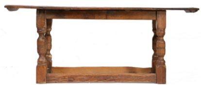 An oak refectory table, the three plank top above turned supports united by stretchers, made from