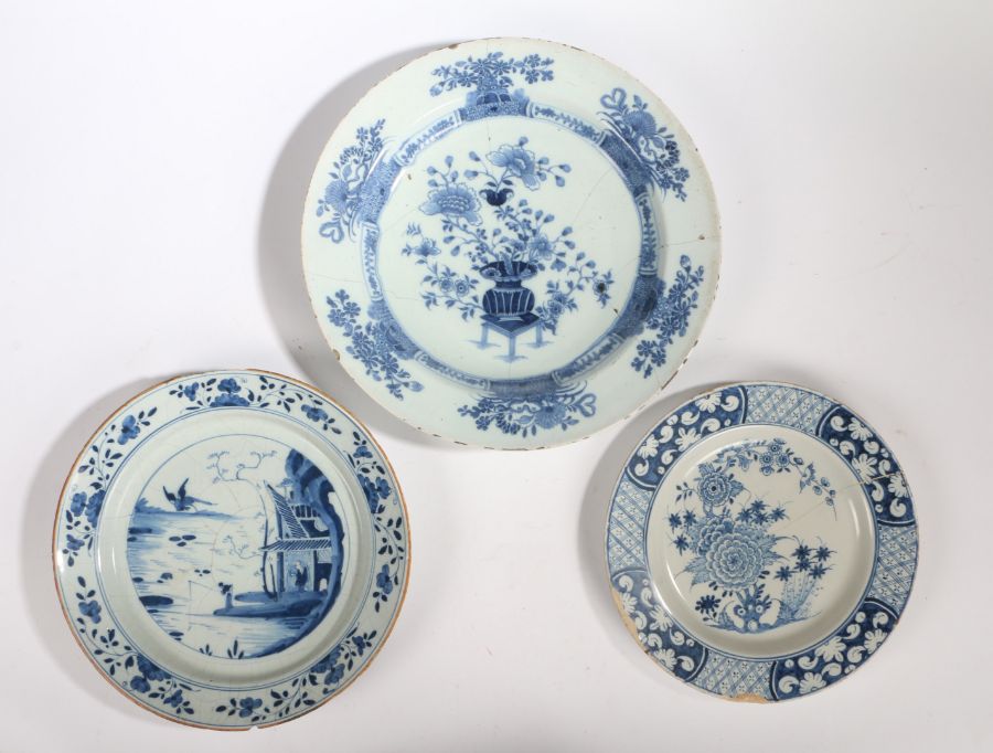 Three 18th Century Delft chargers, the first with an Oriental scene and a phoenix flying above a