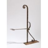 An 18th Century steel toasting fork, the adjustable fork arm on a notched rod and scroll mounts,