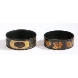 Two Regency papier mache coasters, the first with a black ground decorated with gilt flowers and