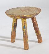 A 19th Century Irish stool, the multiple layer painted circular top above angled legs, 24.5cm
