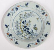 An 18th Century Delft plate, circa 1750, with a stork standing by a tree and flowers, 22,5cm