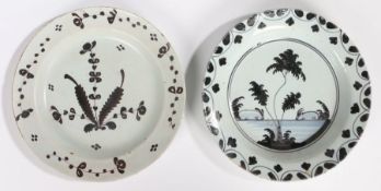 An 18th Century Delft plate, in black tones with a tree and landscape, the border with an arching