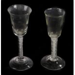 Two George III wine glasses with trumpet bowls above air twists and conical foots, pontil marks to