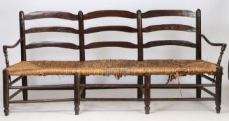 A large 18th Century French mulberry wood provincial radassier/sofa, the triple ladder back above