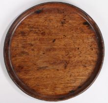 A George III mahogany coaster, circular with a raised lip, 22,5cm diameter