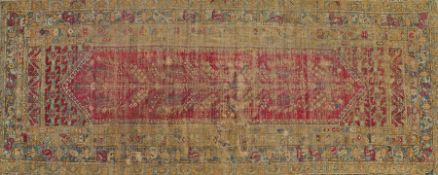 A 17th Century Ghiordes rug, Turkish, with a floral motif to the centre on a red ground with a