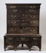 An 18th Century oak chest on stand, the rectangular top with a cushion moulded drawer above two