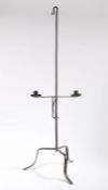 An 18th Century steel dual candle holder, the hook top above an adjustable candle stand and tripod