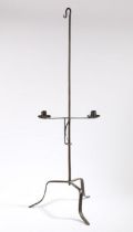 An 18th Century steel dual candle holder, the hook top above an adjustable candle stand and tripod