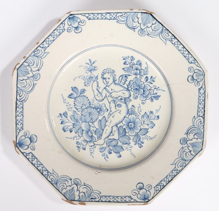 An 18th Century Delft plate, probably Bristol, with a cherub among flowers, with a flower and