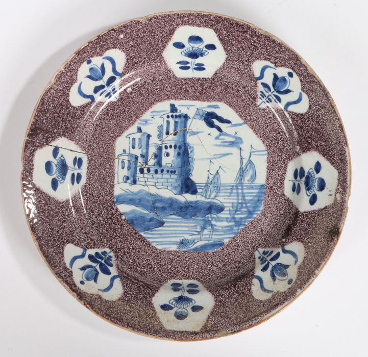 An 18th Century English delft manganese-ground plate, Bristol, circa 1740, painted in blue with an