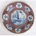 An 18th Century English delft manganese-ground plate, Bristol, circa 1740, painted in blue with an