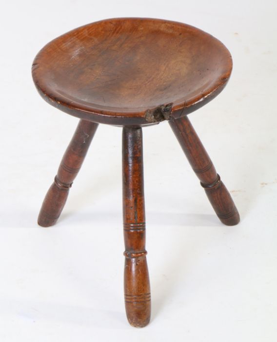 A 19th Century sycamore and ash stool, the circular dished top above three ring turned angled