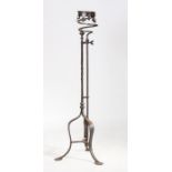 A large iron candle holder, the collar top above a scroll apron on twist column and arched