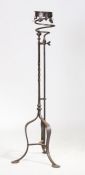 A large iron candle holder, the collar top above a scroll apron on twist column and arched