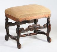 A beech foot stool, the stuff over upholstered top above scroll supports united by turned